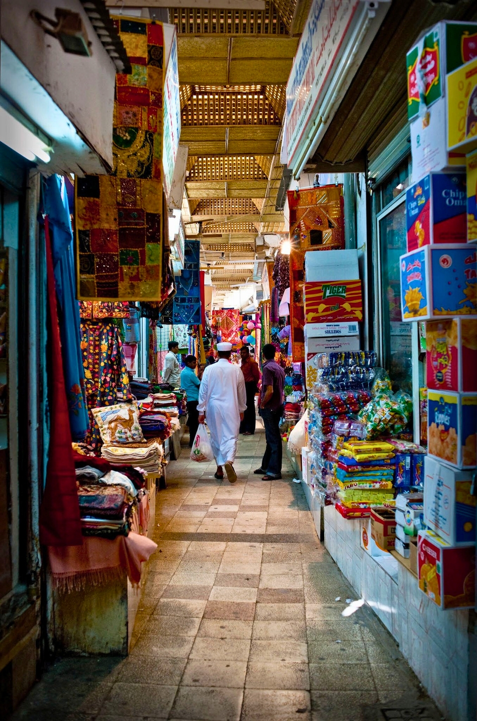 Mutrah Souq alley with textiles and spices
